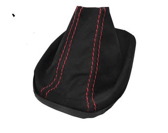 May include: A black gear shift boot with red stitching. The boot is made of a soft, suede-like material and has a rounded base. The red stitching runs vertically along the sides of the boot.