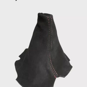 May include: Black suede shift boot with red stitching. The text "Only The Suede Skin Part Is Included" is at the top. The boot has a unique shape with a flared bottom and a tapered top.