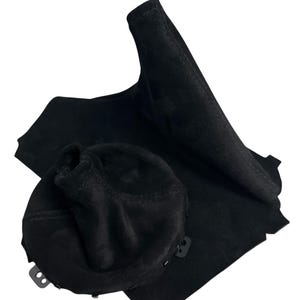 Puede incluir: Juego de funda de palanca de cambios y cubierta de pomo de cambio de coche de ante negro. El juego incluye una funda de palanca de cambios, una cubierta de pomo de cambio y un trozo plano de material de ante. La funda es alta y cónica.