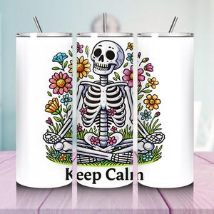 May include: A white tumbler featuring a cartoon skeleton in a yoga pose, surrounded by colorful flowers. The text "Keep Calm" is at the bottom. The tumbler has a silver lid and a straw.