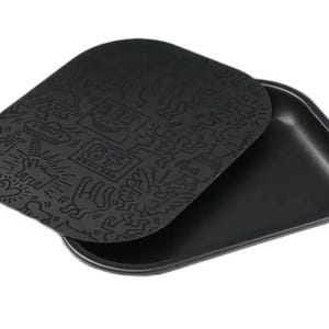 May include: Black rolling tray with a matching lid. The lid features a detailed, embossed design with various figures and the number "84". The tray is rectangular with rounded corners.