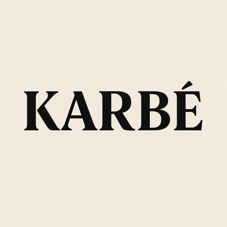 K&ouml;nnte beinhalten: Das Wort "KARB&Eacute;" wird in einer fetten, schwarzen Serifen-Schriftart auf cremefarbenem Hintergrund angezeigt. Der Akzent &uuml;ber dem "E" verleiht dem Design einen Hauch von Eleganz. Die Gesamt&auml;sthetik ist sauber und modern.