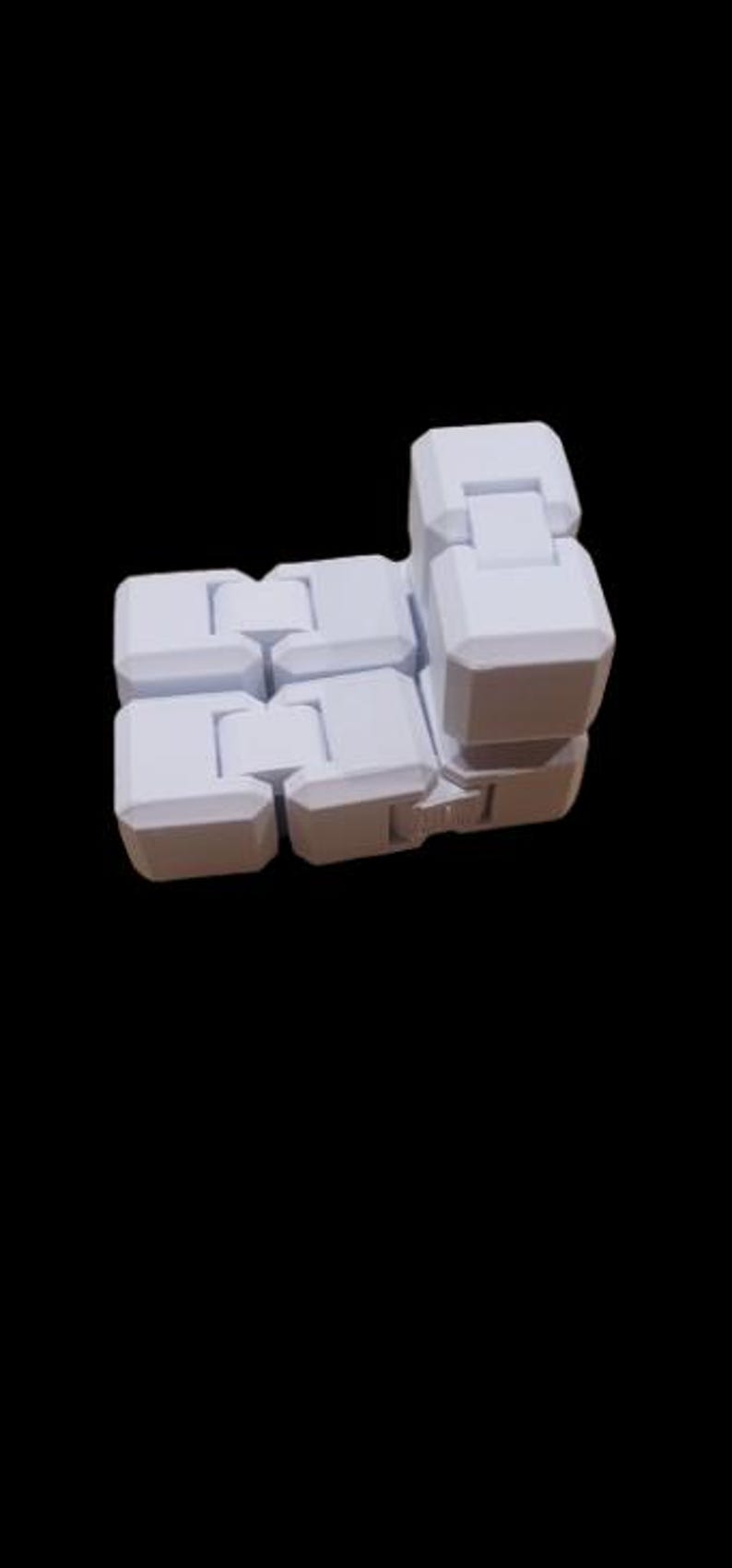 May include: A white, articulated fidget toy, made up of several connected, rectangular blocks. The blocks are joined by hinges, allowing for flexible movement and various configurations. The toy is set against a black background.