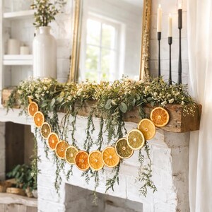 A rustic mantelpiece decorated with a garland of dried lime, lemon, and orange slices.