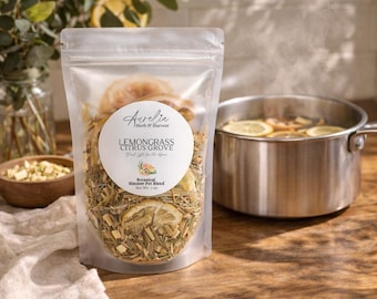 May include: A clear stand-up pouch containing a botanical simmer pot blend with dried lemongrass and citrus slices. The white circular label reads Aurelia Herb & Harvest, Lemongrass Citrus Grove, Botanical Simmer Pot Blend, and Net Wt 1 oz.