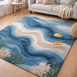 Puede incluir: Una alfombra azul rectangular con un diseño de olas, que representa una escena oceánica. La alfombra tiene tres peces y detalles de coral. Está colocada sobre un suelo de madera, creando un tema costero.