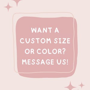May include: A light pink graphic with a rounded square border in a darker shade of pink. The text in white reads: WANT A CUSTOM SIZE OR COLOR? MESSAGE US! There are small, four-pointed star icons in the top left and bottom right corners of the image.