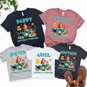 May include: Five short-sleeved t-shirts with colorful graphics. The shirts are navy, mauve, gray, white, and charcoal. Each shirt features a mermaid design with text that reads "Daddy", "Mummy", "Sister", "Ariel 5", and "Brother" with "Birthday Princess".