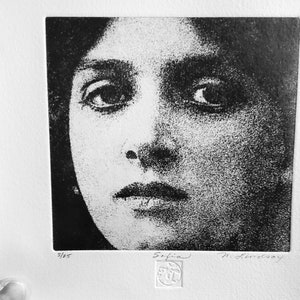 May include: Black and white print of a woman's face. The print is titled "Sofia" and signed "M. Lemoisay". The print number is 3/25.