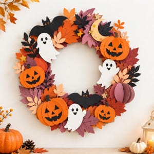 Puede incluir: Una corona circular de Halloween con calabazas naranjas con caras de jack-o'-lantern negras, fantasmas blancos, murciélagos negros y una luna creciente amarilla, decorada con hojas de otoño en tonos naranja, rojo y morado.