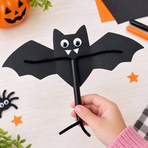 Può includere: Un pipistrello di carta nera fissato a un manico cilindrico nero. Il pipistrello presenta due occhi mobili bianchi, due piccole zanne triangolari bianche e scovolini neri che si estendono per formare le ali e una base a forma di coda.