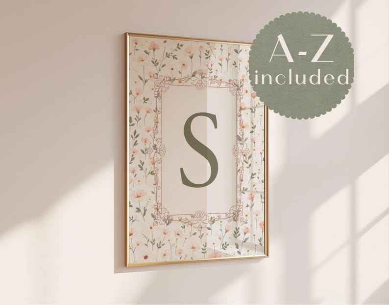 May include: A framed floral print with the letter "S" in green. The artwork is in a gold frame, with a floral pattern and the text "A-Z included" in a circular design. The print is a decorative piece.