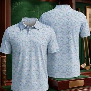 Puede incluir: Polo de color azul claro con un patr&oacute;n geom&eacute;trico repetitivo en tonos azules y verdes. La camisa tiene un cuello cl&aacute;sico y mangas cortas. Una segunda camisa es visible en el fondo.
