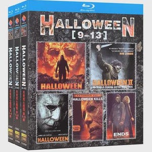 Puede incluir: Un set de cajas Blu-ray con la serie de películas de Halloween, incluyendo las películas 9-13. El set tiene una parte superior azul y un fondo oscuro y texturizado con imágenes de las películas. Los títulos "Halloween" y "Halloween Kills" son visibles.