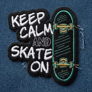 May include: Embroidered patch featuring a black skateboard with teal accents and gold-colored hardware. The patch includes the text "KEEP CALM AND SKATE ON" in white lettering on a black background. The patch is on a blue denim background.