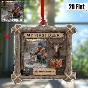 May include: A rustic wooden frame ornament with a photo of a person with a deer, the text "MY FIRST DEER!", and "BROCK HICKS 2019 - PIKE COUNTY, IL". The ornament includes a deer head, a hunting bag, and a rifle.