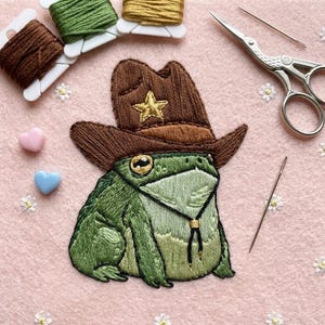 May include: A white ceramic mug with a black handle and the text "But First, Coffee" in a black, bold font. The mug is on a white surface. The mug is 4 inches tall.