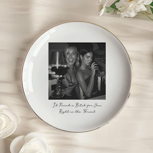 May include: White ceramic plate with a gold rim, featuring a black and white photo of two women. The plate has the text "I'd Punch a Bitch for You Right in the Throat" in a script font.