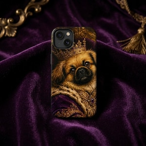 Puede incluir: Funda de teléfono con un retrato de un perro real con corona. La imagen muestra un perro pequeño y marrón con una corona, sobre un fondo púrpura. La carcasa de la cámara es negra.