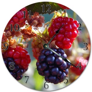 May include: A clock with a close-up image of blackberries and raspberries. The clock face has black numbers on a white background.