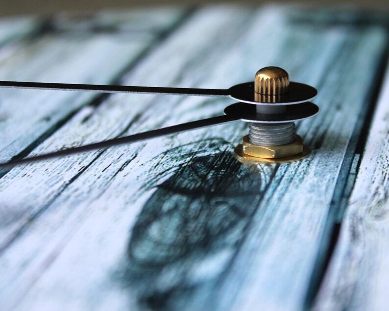 a close up of a clock on a wooden surface