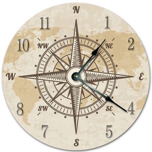 Peut inclure: Horloge murale ronde avec un motif de rose des vents marron et beige. Le cadran affiche les points cardinaux, les chiffres et une carte du monde en arrière-plan. Les aiguilles de l'horloge sont noires.