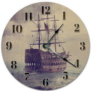 Peut inclure: Horloge murale ronde avec une illustration vintage d'un grand voilier en mer. Le cadran de l'horloge a un aspect vieilli et patiné, avec de grands chiffres sombres et des aiguilles noires. Le navire a plusieurs mâts et voiles, avec un drapeau rouge. Mesure environ 30 cm de diamètre.
