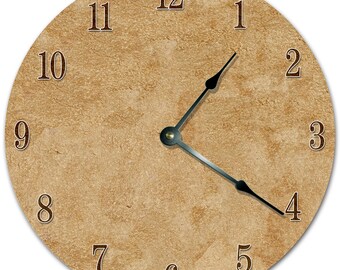 May include: A round clock face with a textured, tan background. Dark brown numerals mark the hours. The clock hands are black and point to approximately 1:20. The clock face is a decorative item.