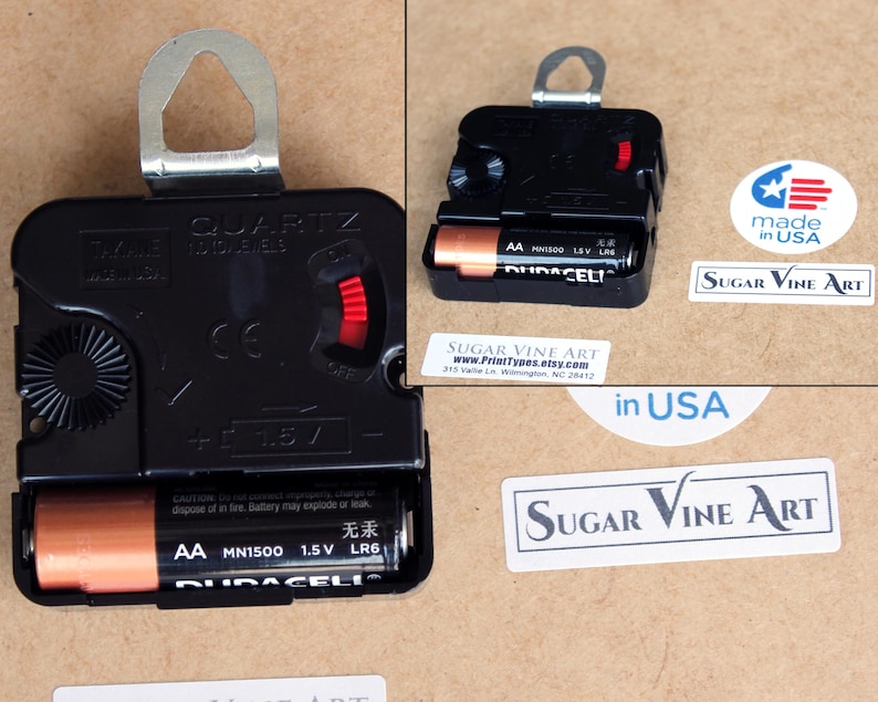 a black electronic device, possibly a clock, with a battery and a label indicating it is made in the USA.