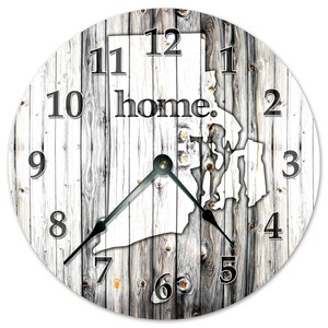 May include: Circular wall clock with a distressed wood effect. The clock face displays the outline of Rhode Island, the word "home" in black, and black numerals. The clock hands are black and the clock is approximately 30 cm in diameter.