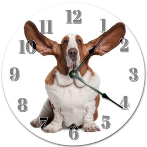 Peut inclure: Horloge murale ronde avec un Basset Hound. Le chien, marron et blanc, est au centre d'un cadran blanc avec des chiffres gris et des aiguilles noires. Un élément de décoration intérieure original.