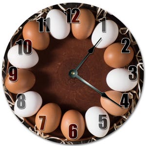 May include: A brown clock face with white and brown eggs arranged around the edge, representing the numbers 1 through 12. The clock hands are black and point to the time 3:45.