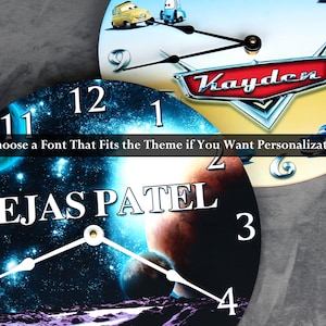 a clock with a space-themed design, including a planet and stars. The clock also has a personalized name on it.