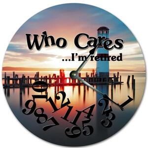 May include: Circular wall clock with a sunset scene, a lighthouse, and a pier. The clock face has the text "Who Cares...I'm retired" in black, with black numerals and hands. A decorative item for the home or office.