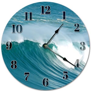 May include: Round wall clock featuring a vibrant ocean wave design. The clock face displays black numerals and hands against a backdrop of a crashing turquoise wave. The clock's hands point to approximately 4:20.