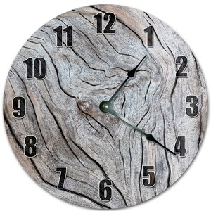 Peut inclure: Horloge murale ronde avec un motif de grain de bois vieilli. Le cadran de l'horloge présente des chiffres noirs et des aiguilles noires. Le fond a une texture de bois naturel dans des tons de gris et de brun.