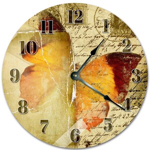 Peut inclure: Horloge murale ronde avec un motif d'aile de papillon aux tons orange, jaune et marron. Le cadran de l'horloge a une esthétique vintage avec un fond de papier vieilli et d'écriture manuscrite. Aiguilles et chiffres noirs.