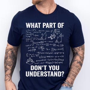 May include: A navy blue t-shirt displaying the text "WHAT PART OF DON'T YOU UNDERSTAND?" in white, along with mathematical formulas. A casual top for maths enthusiasts. The shirt is a great gift idea.