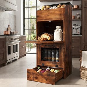 May include: A tall, rustic wooden kitchen storage unit featuring a top bin for produce, a middle shelf with a fold-down door holding bread and a cloth bag, a central cabinet with a black metal mesh door, and a bottom pull-out drawer for vegetables.