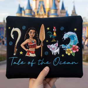 Pu&ograve; includere: Pochette nera con personaggi ricamati ed elementi del film d'animazione. Il design include un personaggio con una lancia, un gancio, un gallo, un maiale, un'onda e fiori. Il testo "Tale of the Ocean" &egrave; scritto in corsivo.