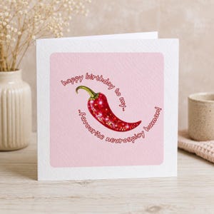 May include: A square greeting card with a light pink centre panel featuring a red chilli pepper with a disco ball texture. The text reads: happy birthday to my.. favourite neurospicy human! The card has a white border and a textured paper finish.