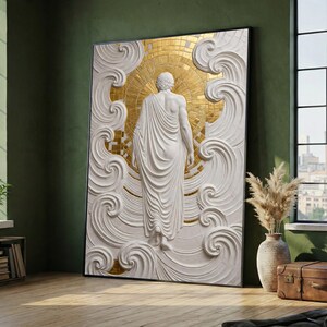 May include: A framed wall art piece featuring a white, three-dimensional relief sculpture of a figure viewed from behind, draped in flowing fabric. The figure is centered against a circular, radiant gold mosaic background with swirling white patterns.