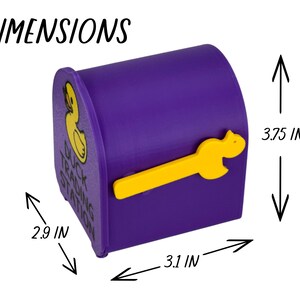 May include: A purple mailbox-shaped container with a yellow duck-shaped handle. The container has a yellow duck logo and the text "Duck Trading Station". Dimensions are 3.75 inches high, 2.9 inches wide, and 3.1 inches deep.