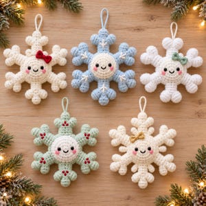 May include: Five crocheted snowflake ornaments with smiling faces, rosy cheeks, and hanging loops. The snowflakes are white, light blue, and pale green, featuring small decorative bows in red, green, and gold, and white embroidered details.