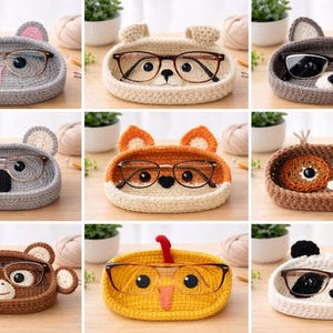 May include: A collection of handmade crochet eyeglass holders in various animal designs. Each holder features a unique animal face, including a koala, bear, raccoon, fox, owl, monkey, bird, and panda. The holders are designed to hold eyeglasses.
