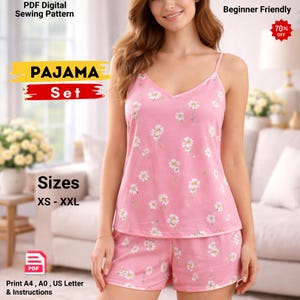 Op de afbeelding: Een roze pyjamaset met een wit madeliefjesbloemmotief. De set bevat een camisole top en shorts. De afbeelding bevat ook de tekst "PAJAMA Set", "Maten XS - XXL" en "Beginner Friendly". Een sticker met 70% korting is ook zichtbaar.