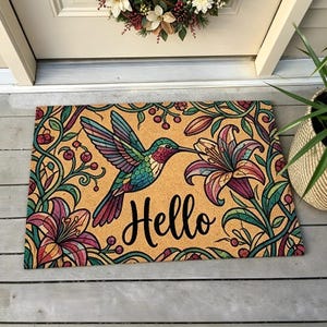 May include: A rectangular doormat with a hummingbird design. The mat features a hummingbird with colourful wings, a flower, and the word "Hello" in black script on a tan background. Green vines and flowers frame the design.