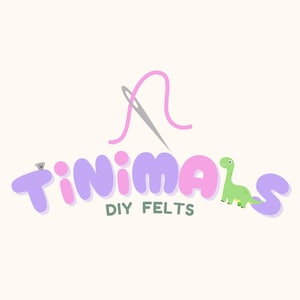 May include: A logo featuring the text Tinimals DIY Felts in rounded purple and pink letters. Above the text is a silver needle with a pink thread loop. A small gray koala sits on the letter T, and a green dinosaur stands on the letter S.