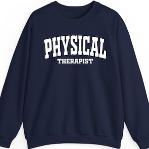 K&ouml;nnte beinhalten: Marineblaues Sweatshirt mit dem wei&szlig;en Aufdruck "PHYSICAL THERAPIST". Das Sweatshirt mit Rundhalsausschnitt ist einfarbig marineblau.