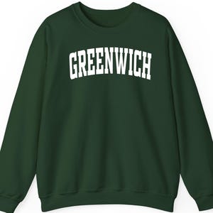 Może przedstawiać: Ciemnozielona bluza z napisem "GREENWICH" w dużych, białych literach na piersi. Bluza ma okrągły dekolt i długie rękawy.